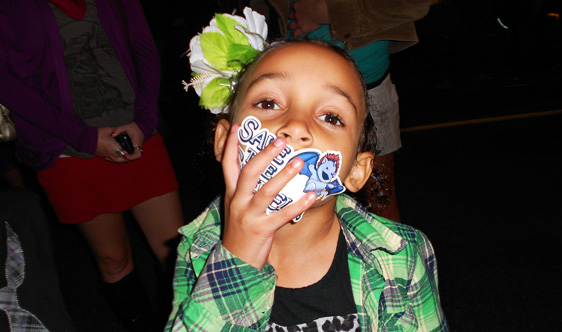 A new fan 'vocalizes' her support for the sperels by slapping one of their stickers right onto her mouth!